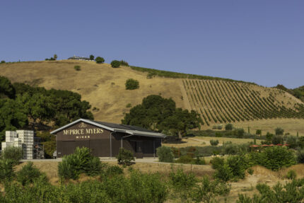 McPrice Myers winery building in front of rolling hills of a vineyard